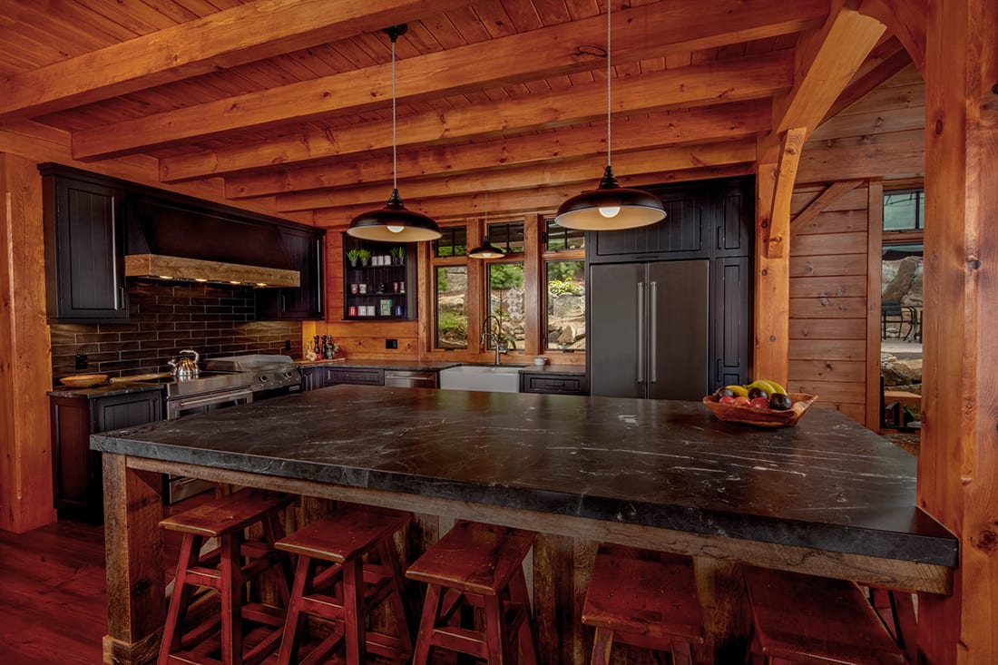 A rustic custom cottage kitchen with distressed black cabinets and reclaimed wood island.