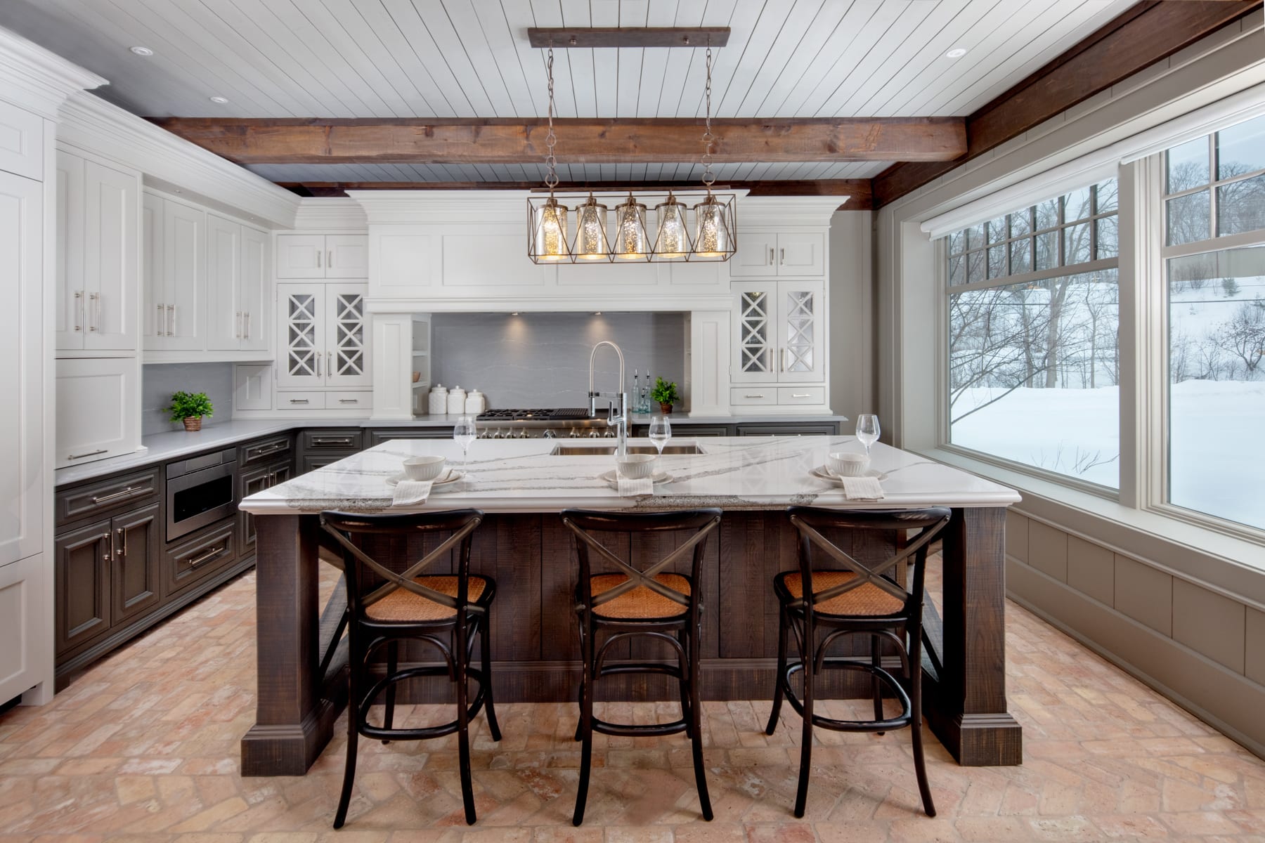 A traditional custom kitchen with a three-tone cabinetry design including white, grey, and band sawn wood.