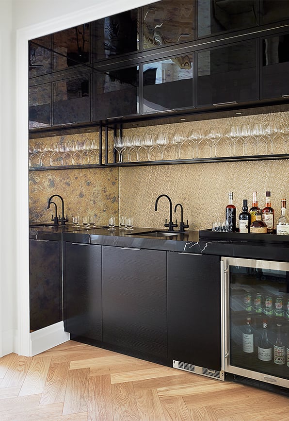 gold and black custom home wet bar with gold backsplash