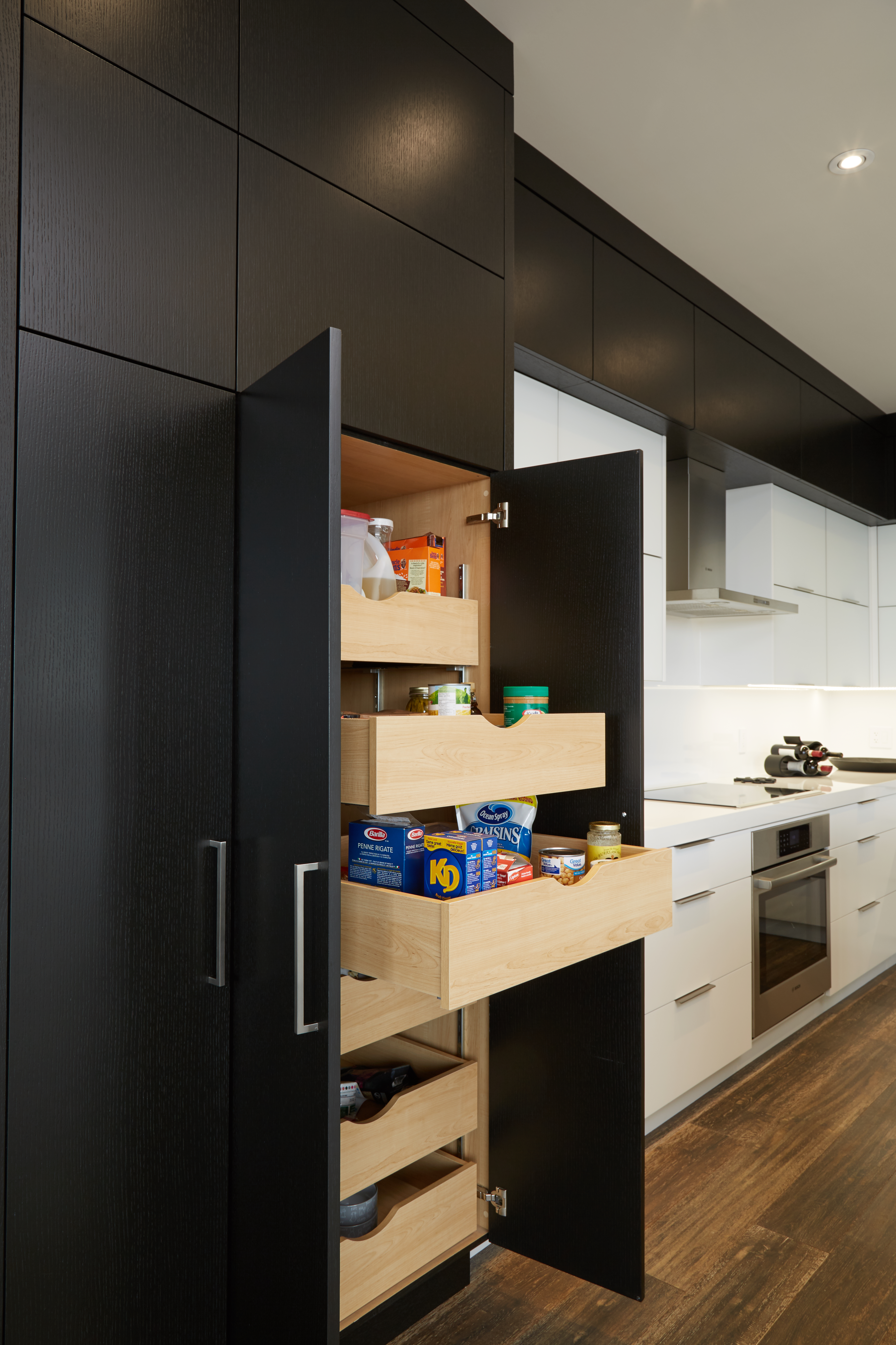 modern white and black kitchen with tall pantry cabinet with roll-out drawers