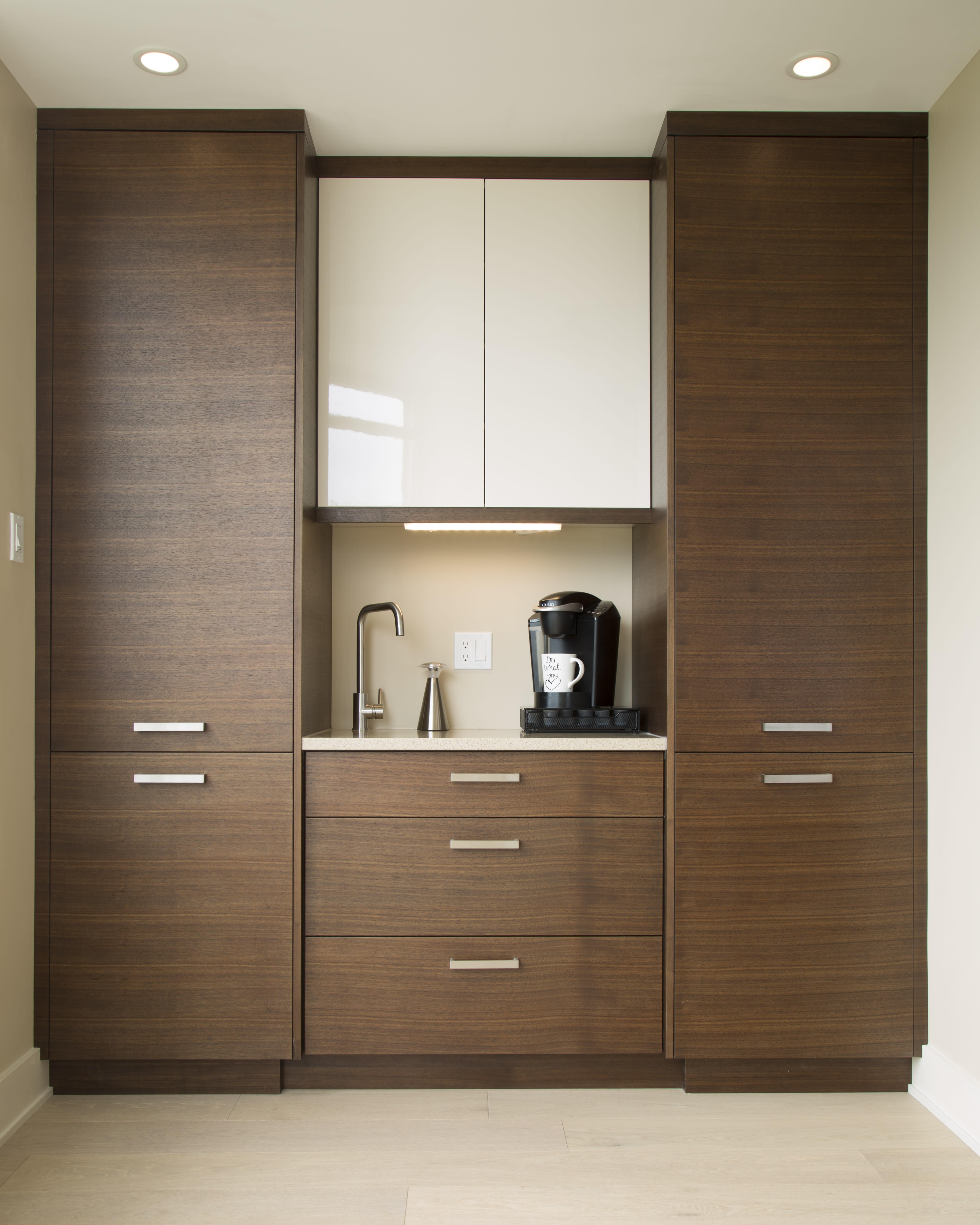 Modern white and wood coffee station with tall tower cabinets