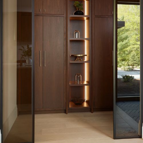 walk in pantry with closed walnut doors and cabinets