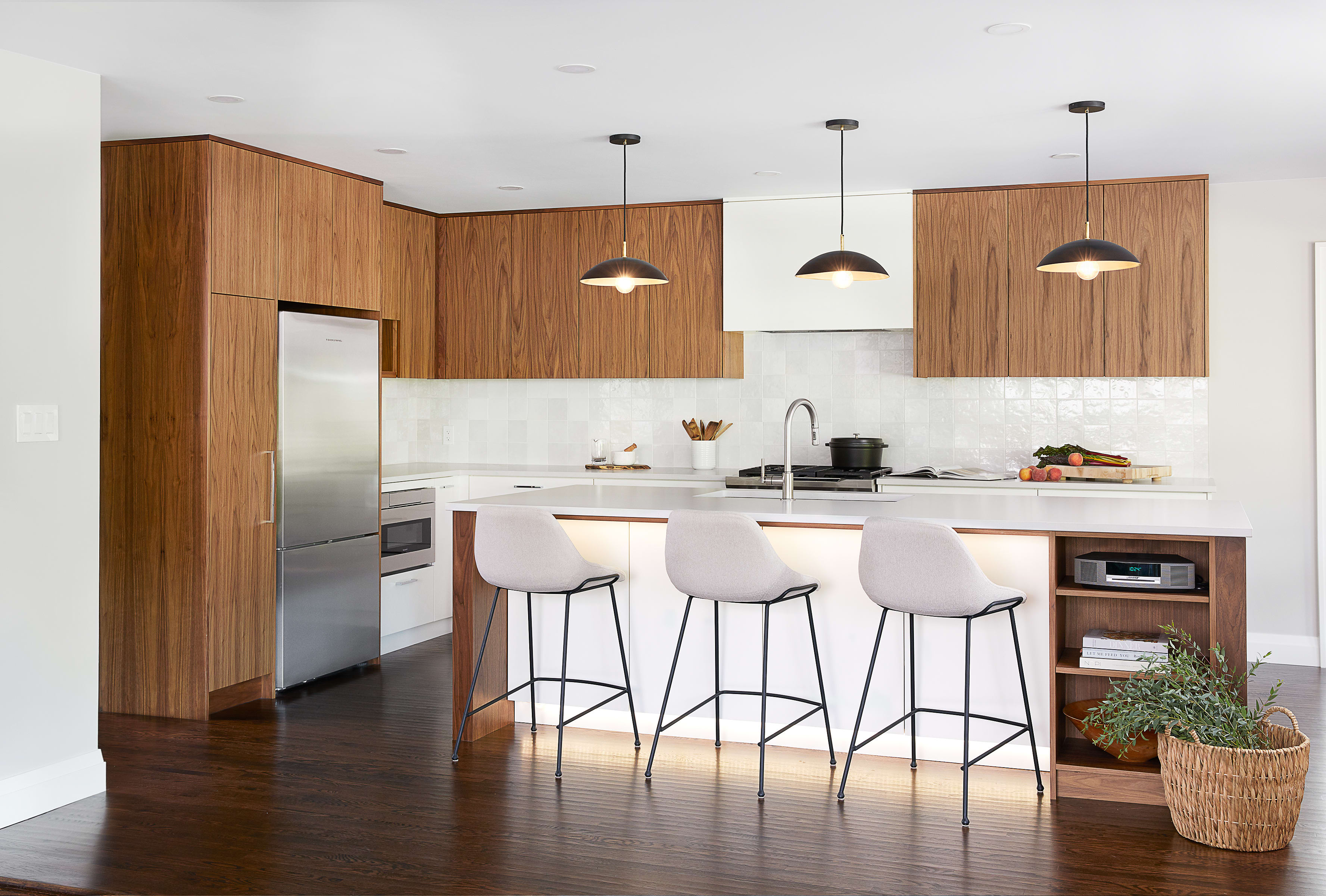 A warm and modern kitchen with painted maple cabinetry and stained flat cut walnut cabinetry.