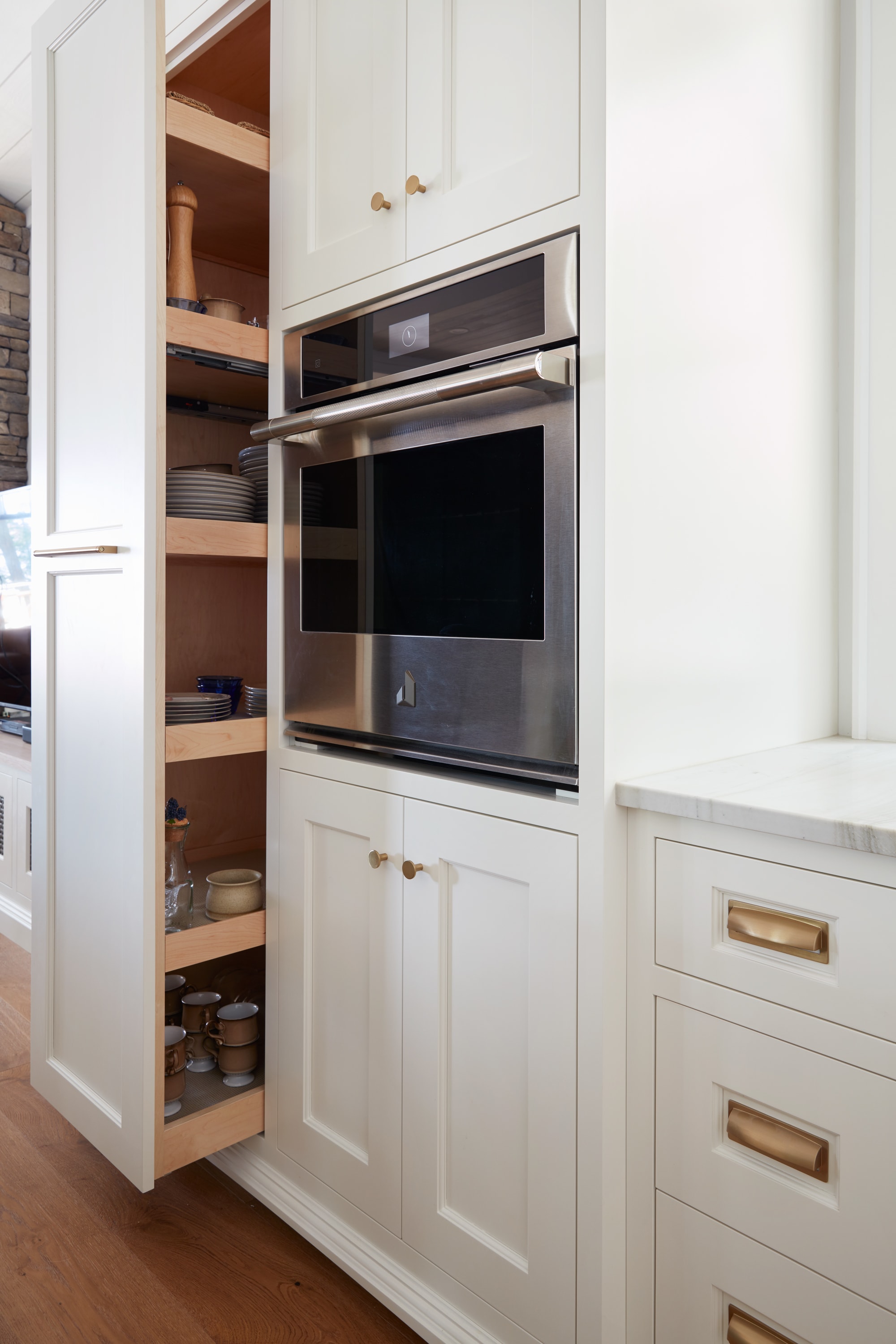 White pantry pull-out cabinet beside wall oven