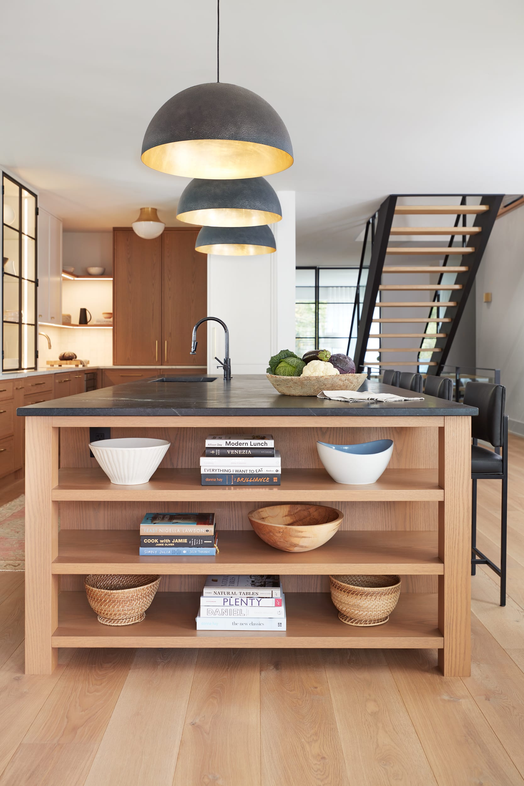 A transitional white oak kitchen with a large island that has an open end display area