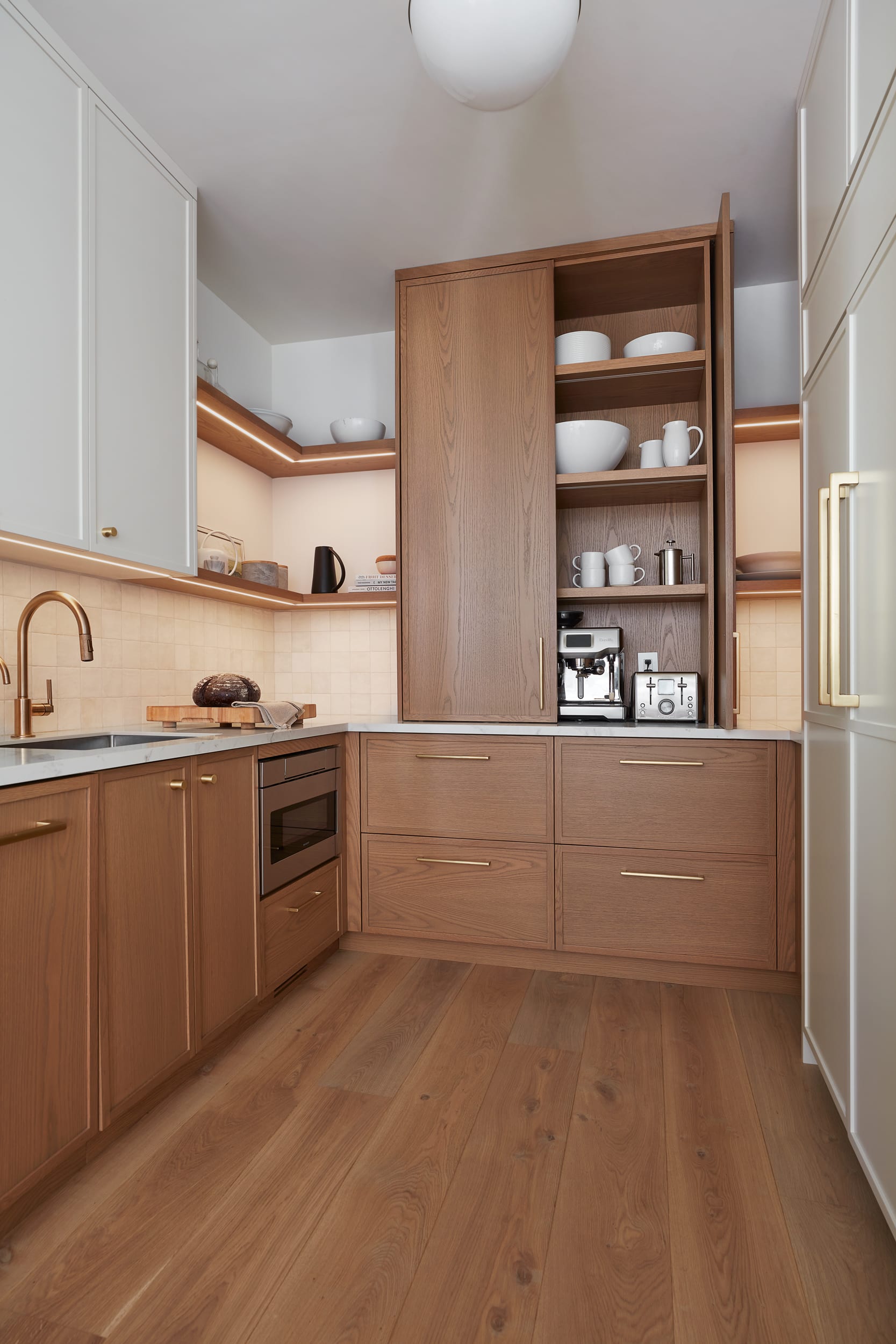 A white oak coffee stationed nestled in the back pantry space of a transitional kitchen