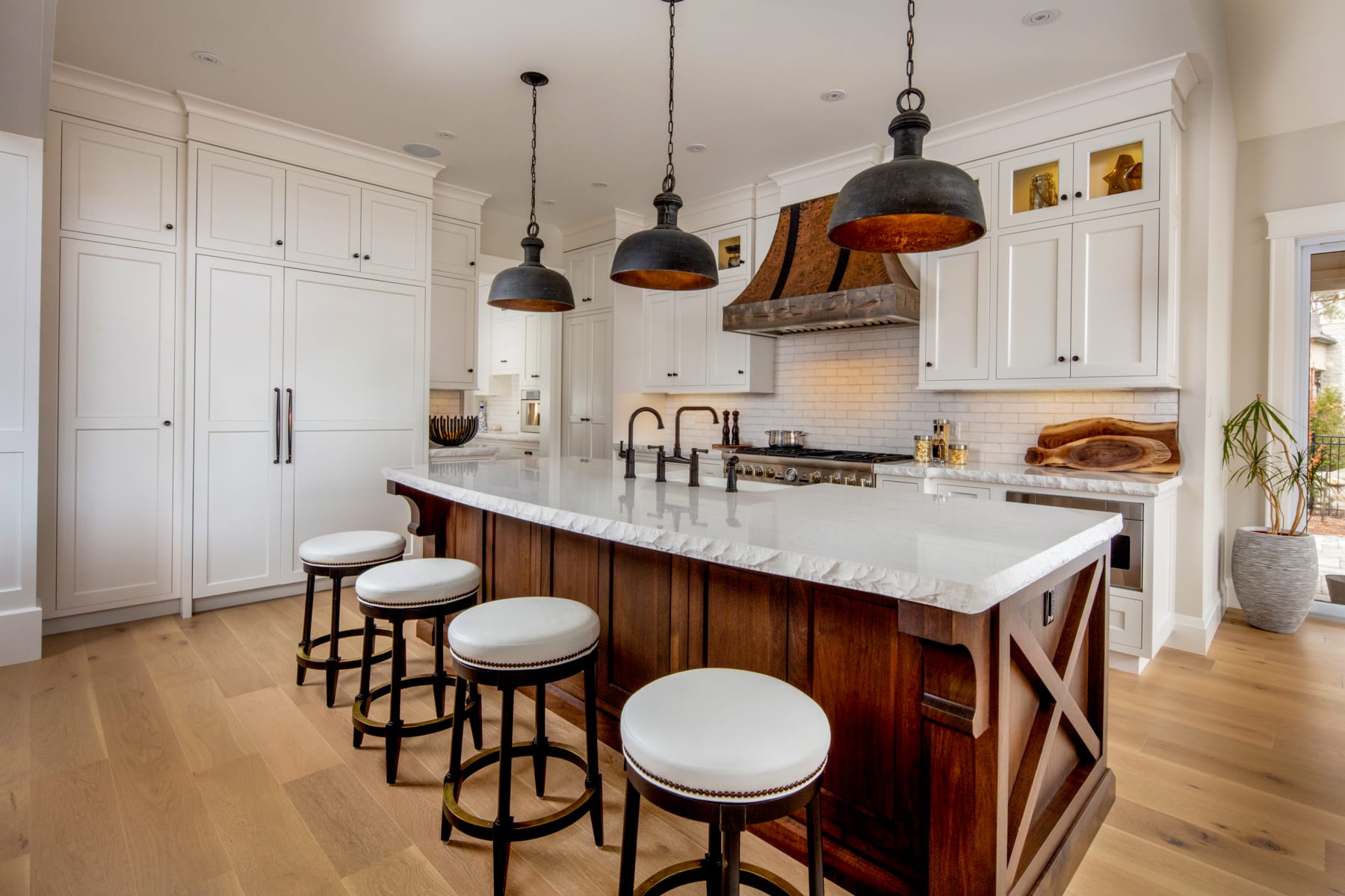 A traditional rustic custom kitchen with white cabinetry and a walnut island.