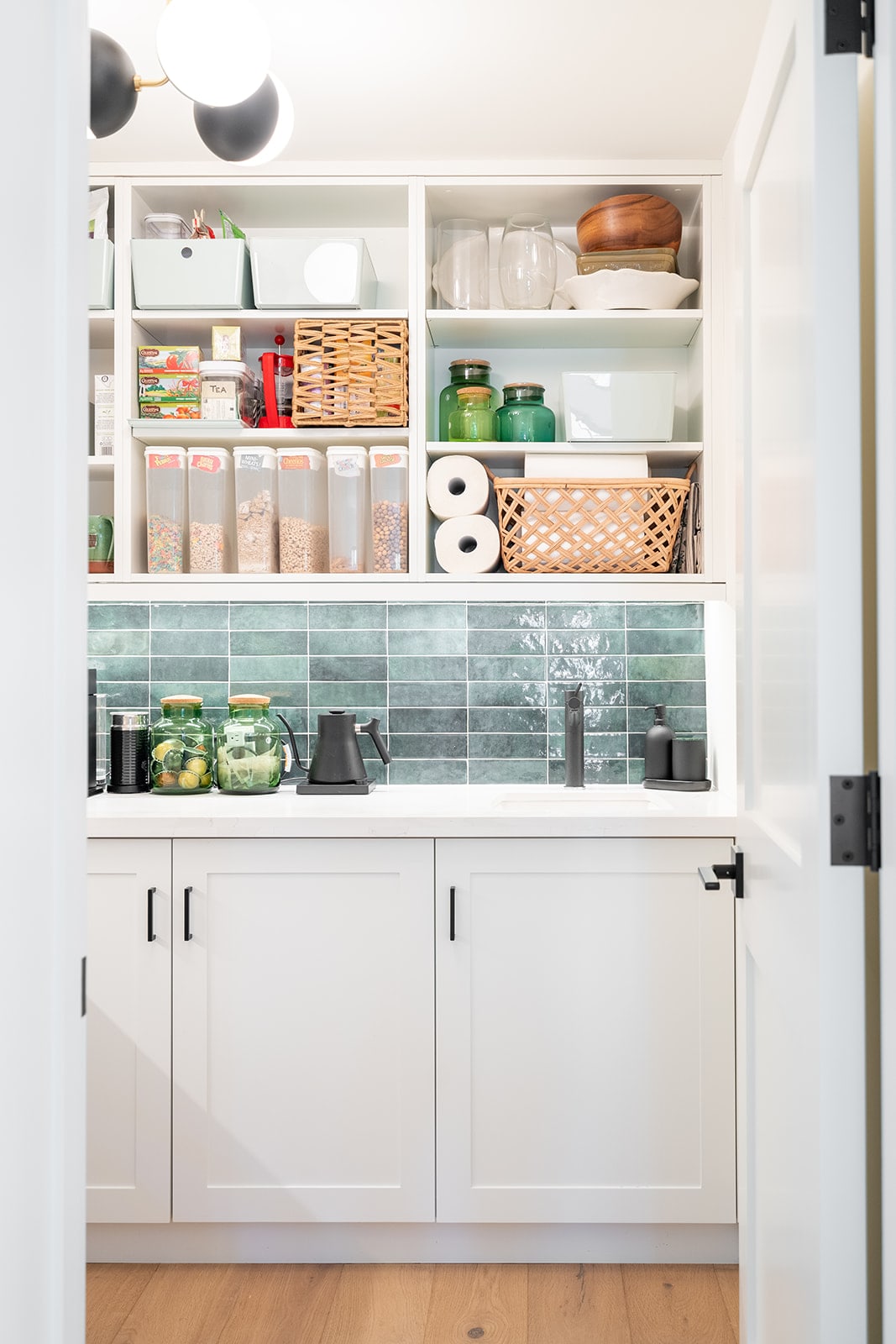 White pantry with open shelving and blue tile backsplash