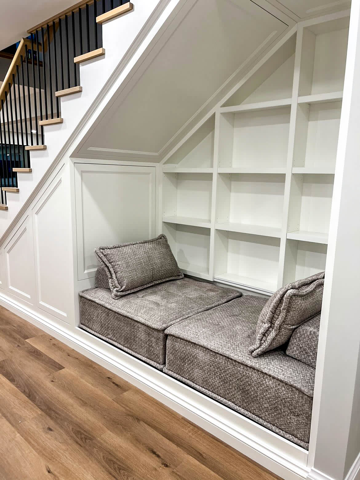 Bench under stairs nook with book shelves to create a reading nook