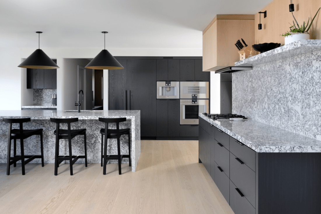 A modern custom kitchen with painted black red oak cabinetry and stained white oak accents.