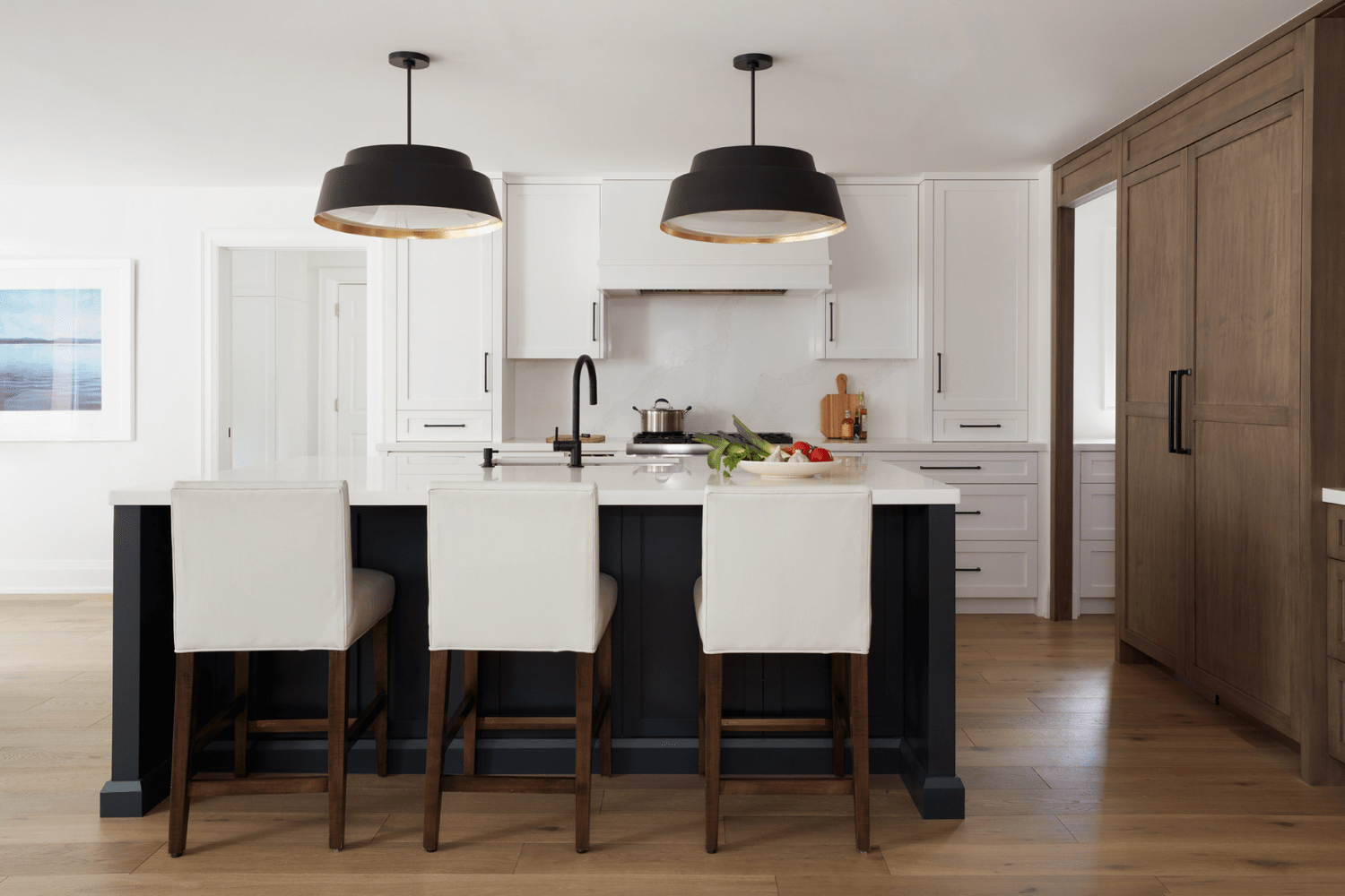 A custom kitchen with dark stained maple cabinets, paired with black and white painted cabinetry. 