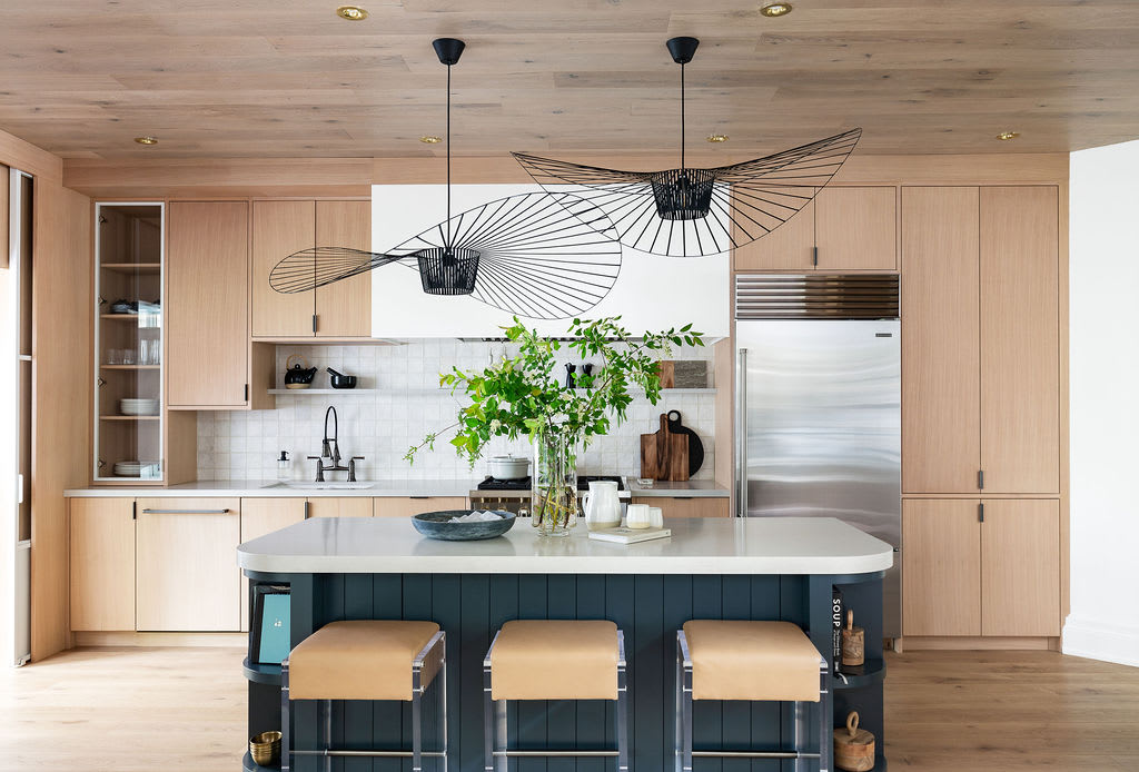 A natural and modern cottage kitchen with rift white oak and a dark blue painted island