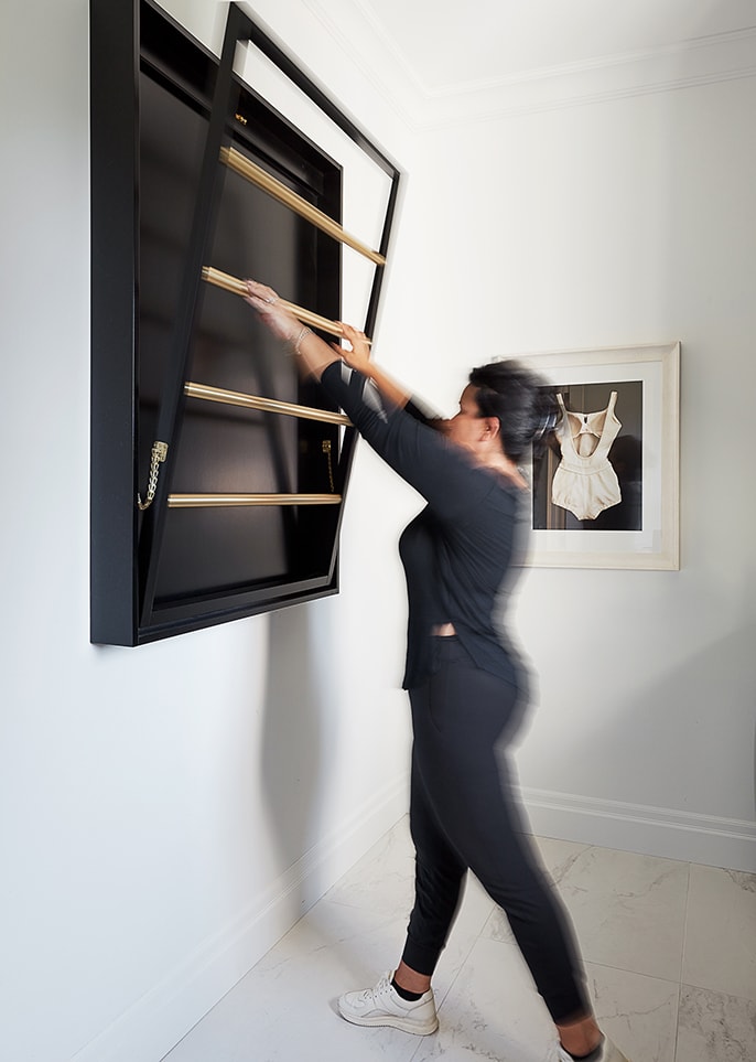 Pulling down drying rack from wall in laundry room