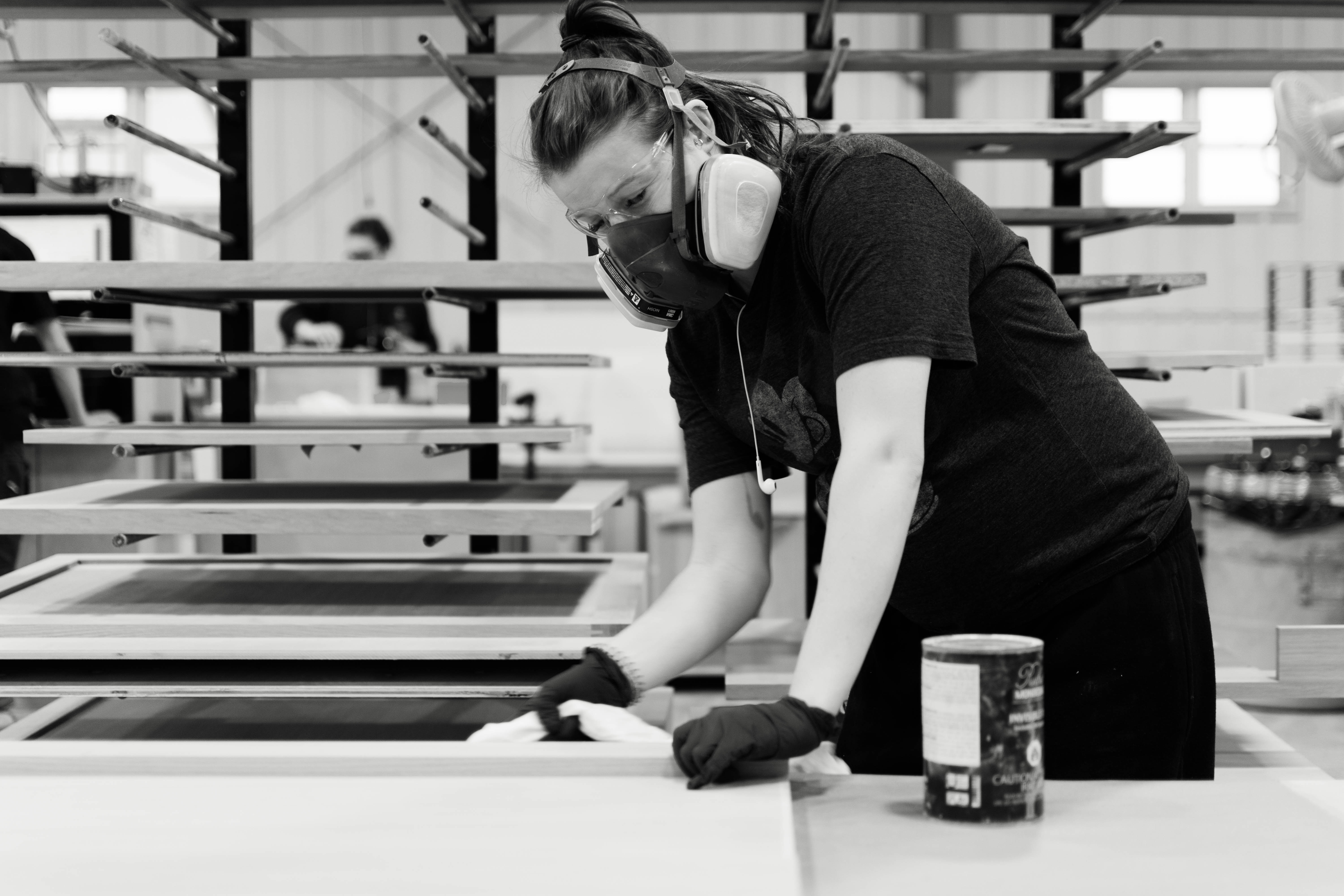 Chervin employee staining kitchen cabinet doors