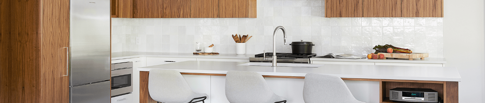 Modern kitchen with white painted cabinetry and natural walnut accents 