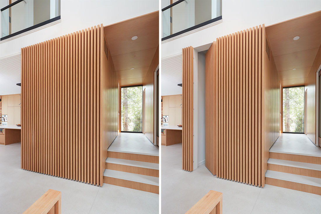 Stunning custom millwork slat wall in white oak that opens to a hidden door to the basement