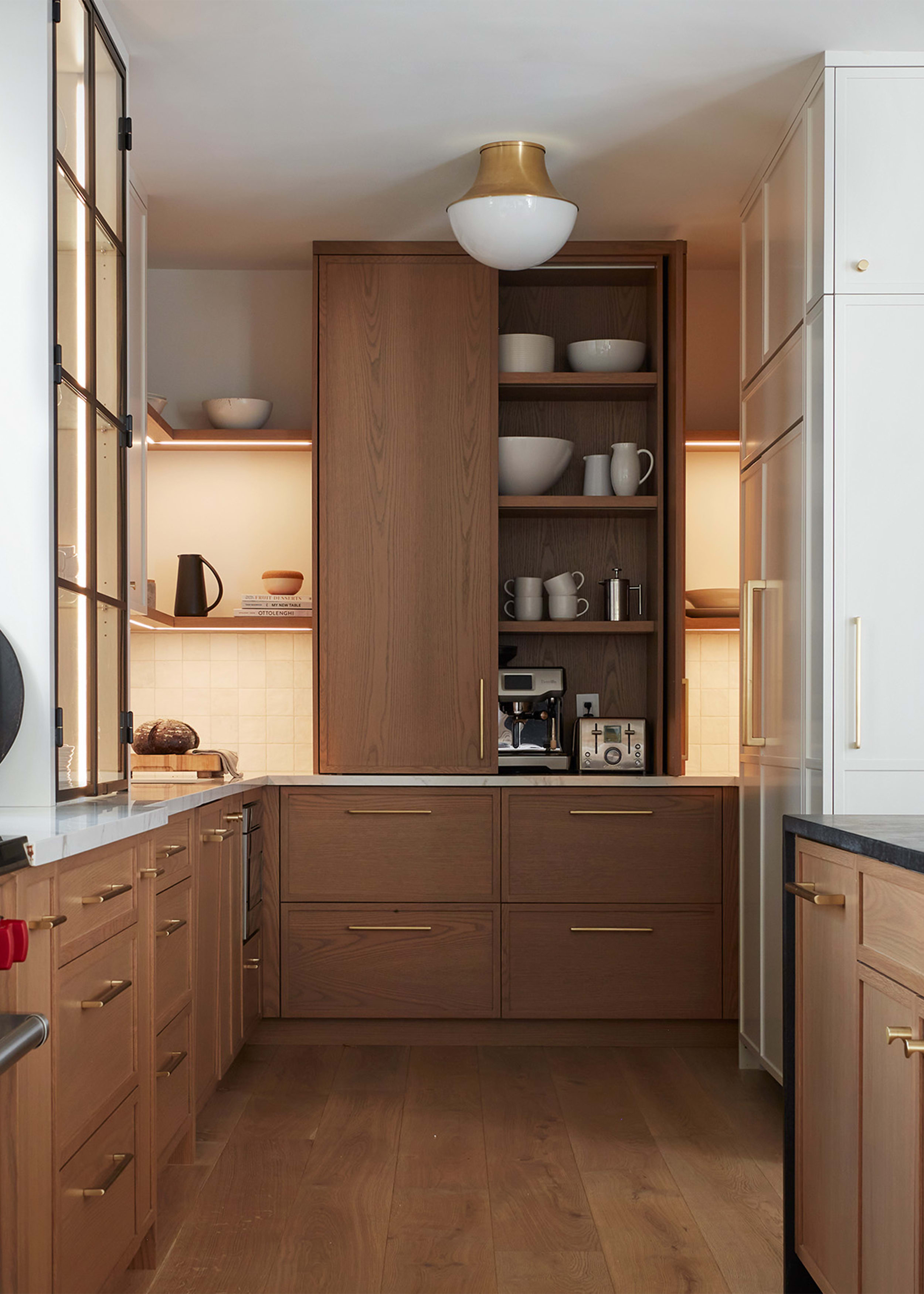 Mid century modern prep area of kitchen with white oak cabinets, open shelving with serving dishes displayed