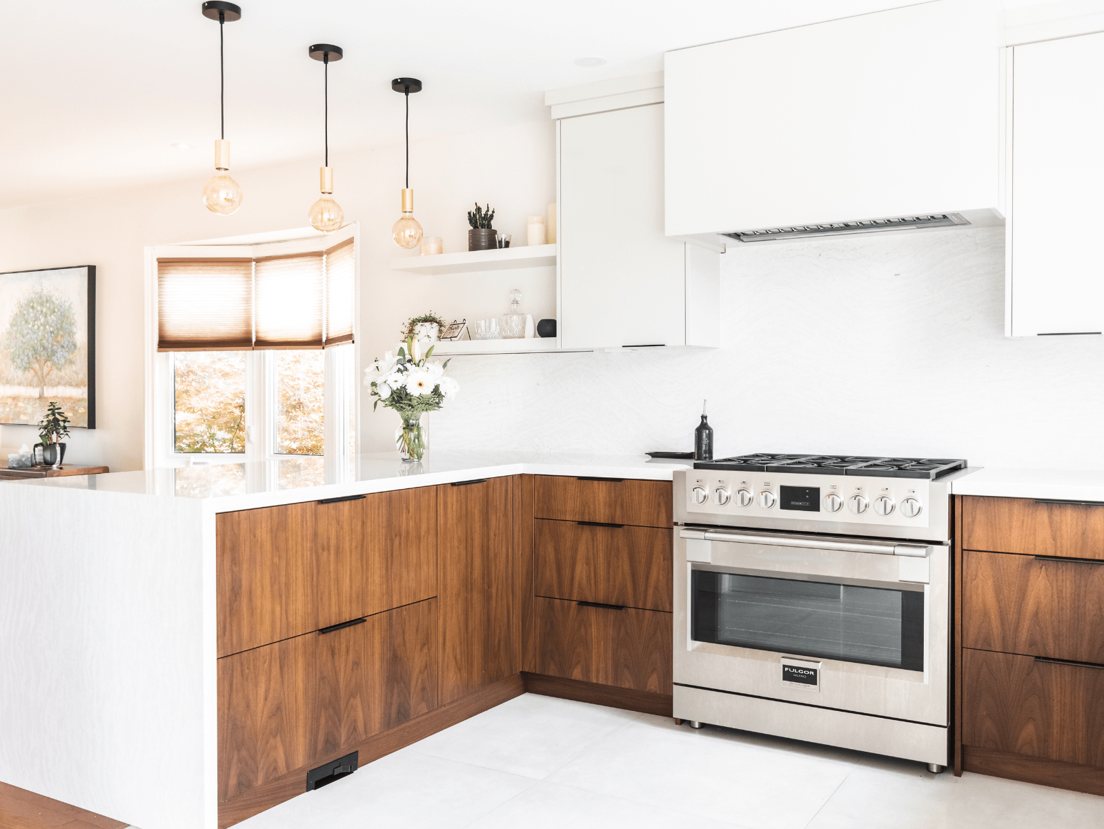 Contemporary kitchen with walnut wood, waterfall quartz peninsula with black hardware pulls