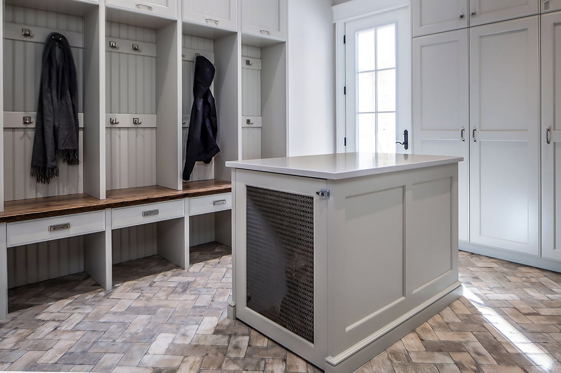 grey painted cabinetry in mudroom with dog cage in island