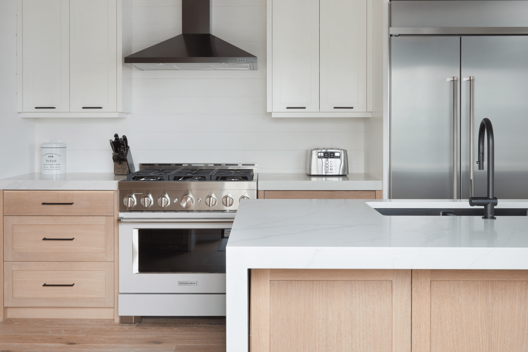 A modern custom cottage kitchen with rift white oak and painted white cabinets.