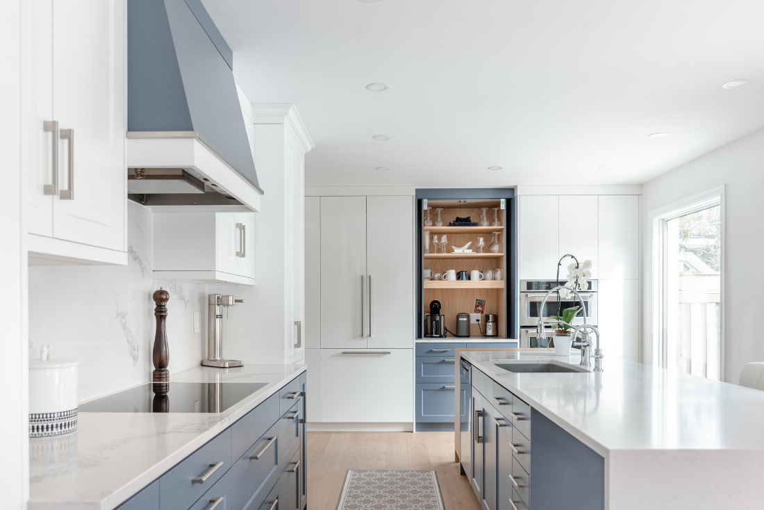 A blue and white transitional kitchen bar with pocket door coffee pantry