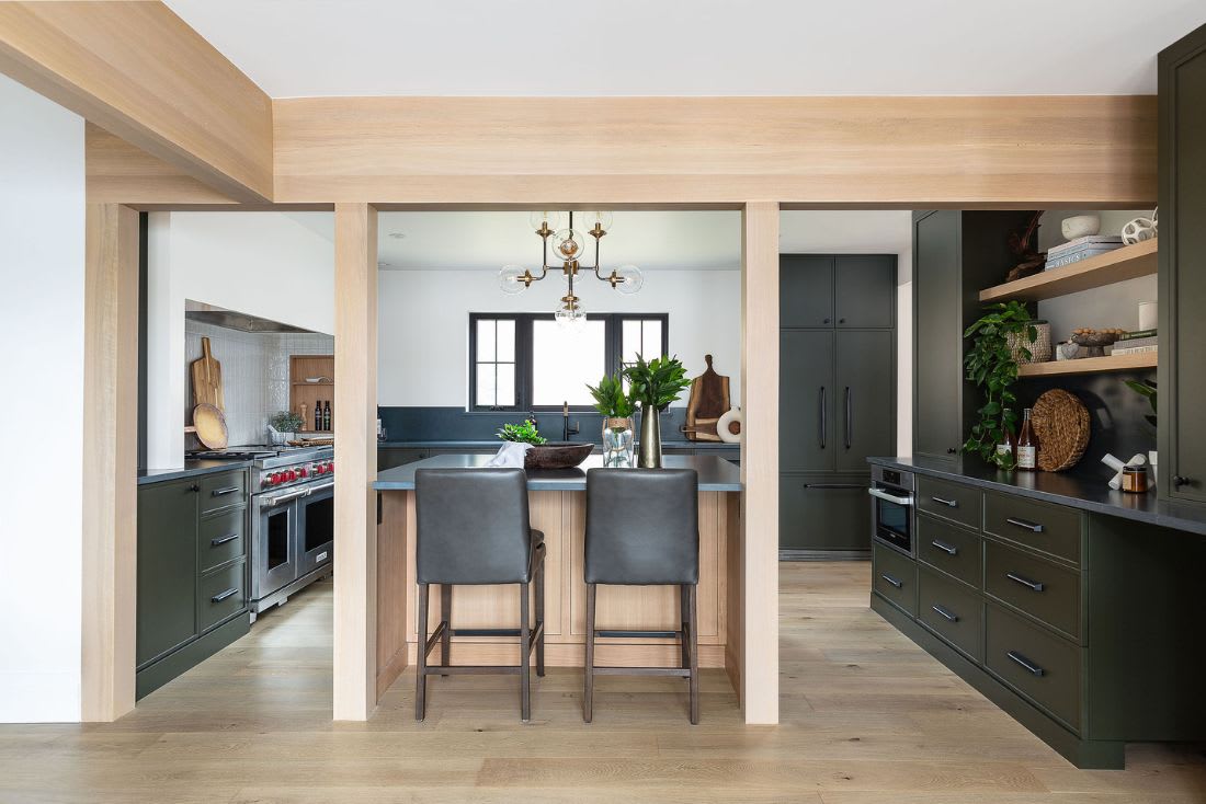 Paint grade coloured u-shaped kitchen cabinets with warm natural oak wood accents and kitchen island. 