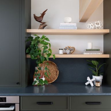 Close up of custom green kitchen cabinets with oak shelving accents