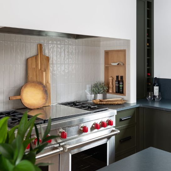 Kitchen corner featuring open shelves and green custom cabinets