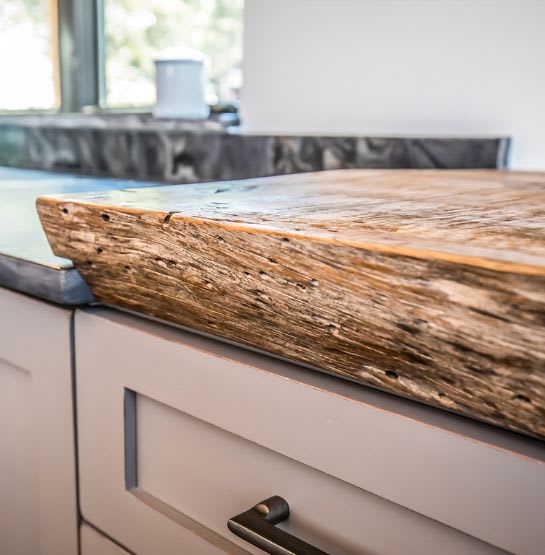 Close up of live-edge wooden kitchen countertop in rustic kitchen