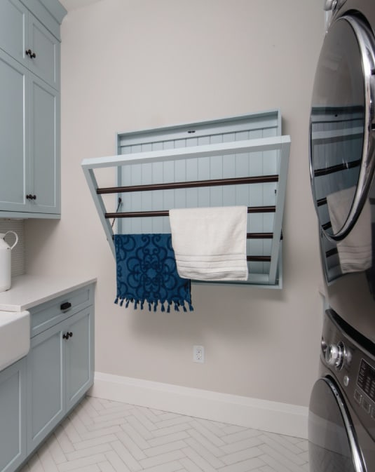 luxury blue laundry room with drying rack