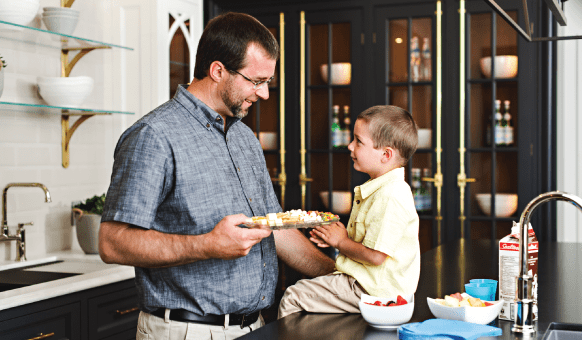 father and son eating a snack in a custom kitchen