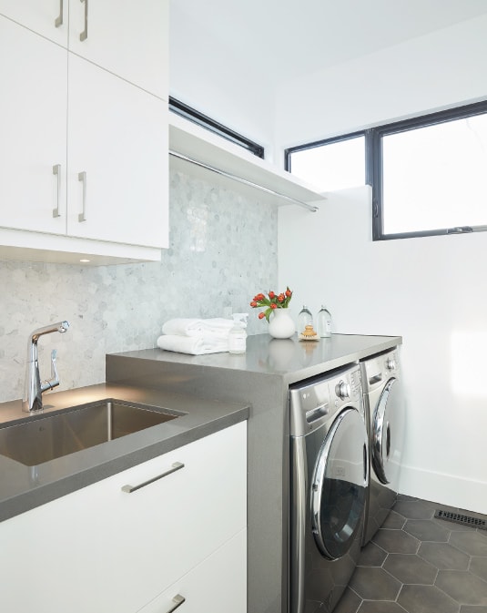 small luxury laundry room with white cabinets and folding area