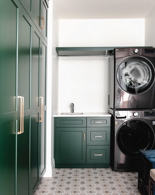 luxury laundry room with emerald green cabinets