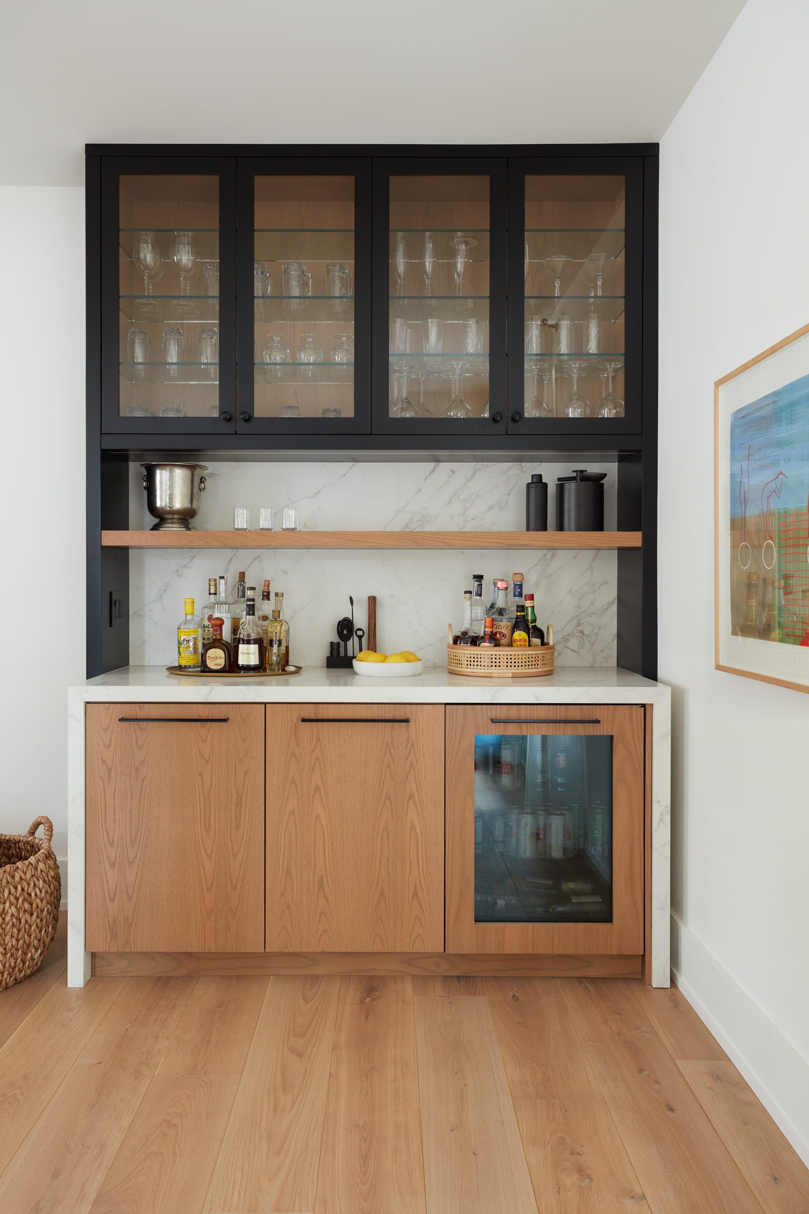 A transitional upstairs bar with rift white oak, black and glass doors
