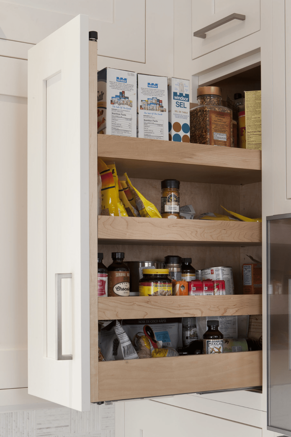 A white pull-out pantry cabinet beside a wall oven